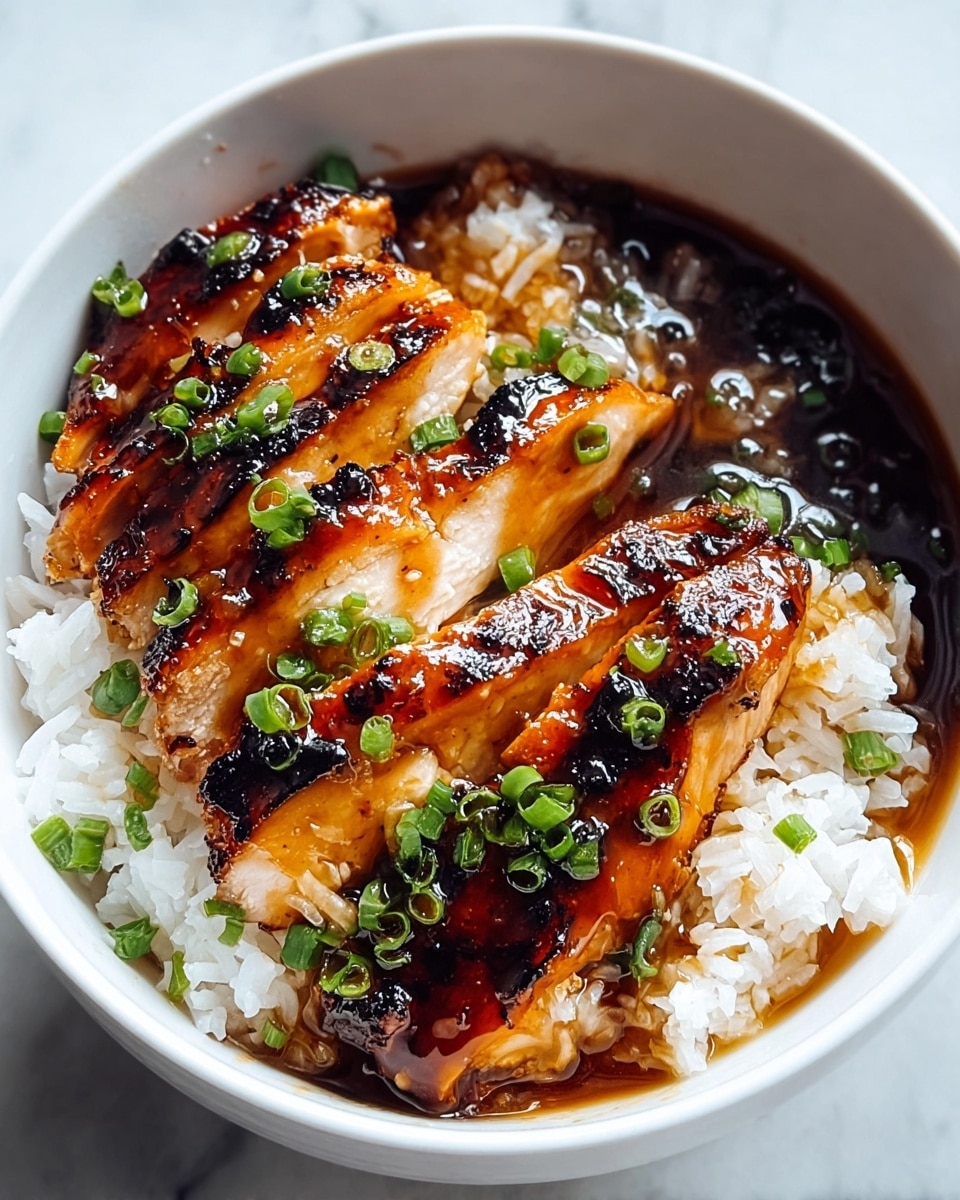 A white bowl filled half with white rice, and on top, three thick slices of grilled chicken with a shiny, dark brown glaze, showing some caramelized black grill marks. The chicken slices are covered with a glossy sauce, pooling in the bottom of the bowl, with small green chopped scallions sprinkled evenly over the chicken and sauce. The bowl sits on a white marbled surface. Photo taken with an iphone --ar 4:5 --v 7