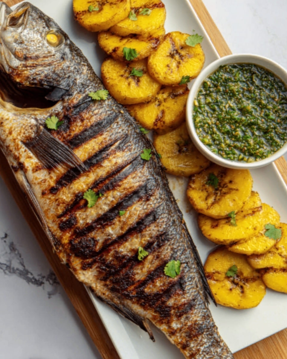 The image shows a whole grilled fish with a dark, crispy skin and char marks, placed on a white plate. To the right of the fish, there are grilled yellow plantain slices arranged in two rows, each slice showing golden-brown grill marks and some green herb garnish on top. Above the plantains, there is a small white bowl filled with a green sauce that has a slightly chunky texture. The plate is set on a white marbled surface. photo taken with an iphone --ar 4:5 --v 7