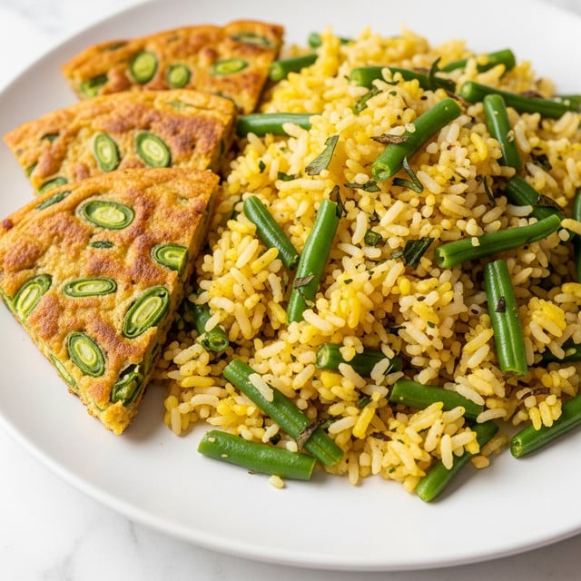 A close-up view of a white plate filled mostly with a mixed rice dish that has fluffy white and yellow grains speckled with green broad beans and small herbs sprinkled all over. On the left side of the plate, there are three triangular pieces of golden-yellow crispy layered flatbread with visible bits of green beans embedded in them, showing a slightly crunchy texture. The colors are bright and natural against a white marbled surface. photo taken with an iphone --ar 4:5 --v 7