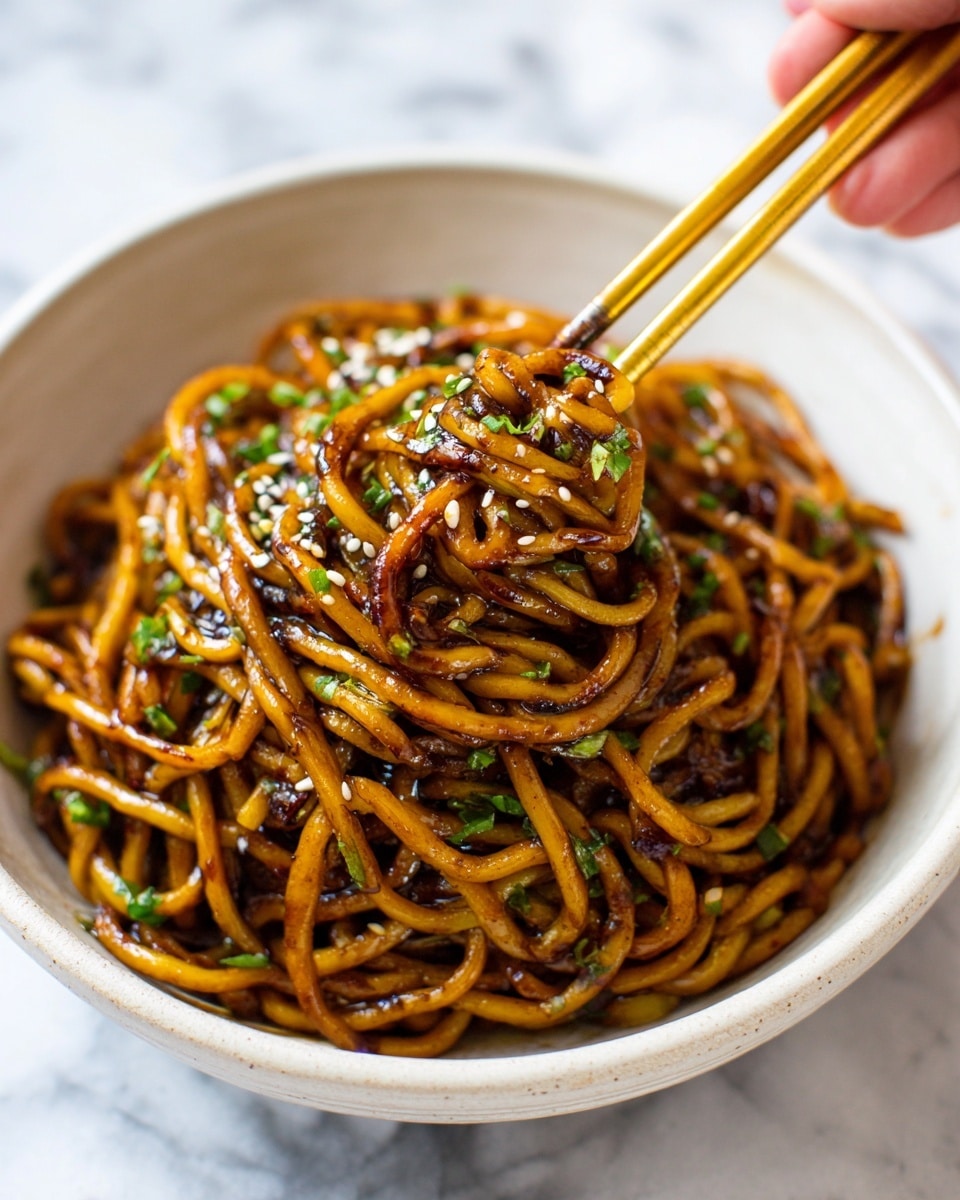 A black bowl filled with cooked noodles covered in a glossy dark brown sauce. The noodles look soft and slightly twisted, mixed with small pieces of cooked vegetables or meat. On top, there are small green chopped herbs sprinkled evenly and white sesame seeds adding texture. A woman's hand is holding wooden chopsticks, lifting some noodles from the bowl. The background features a white marbled texture. photo taken with an iphone --ar 4:5 --v 7