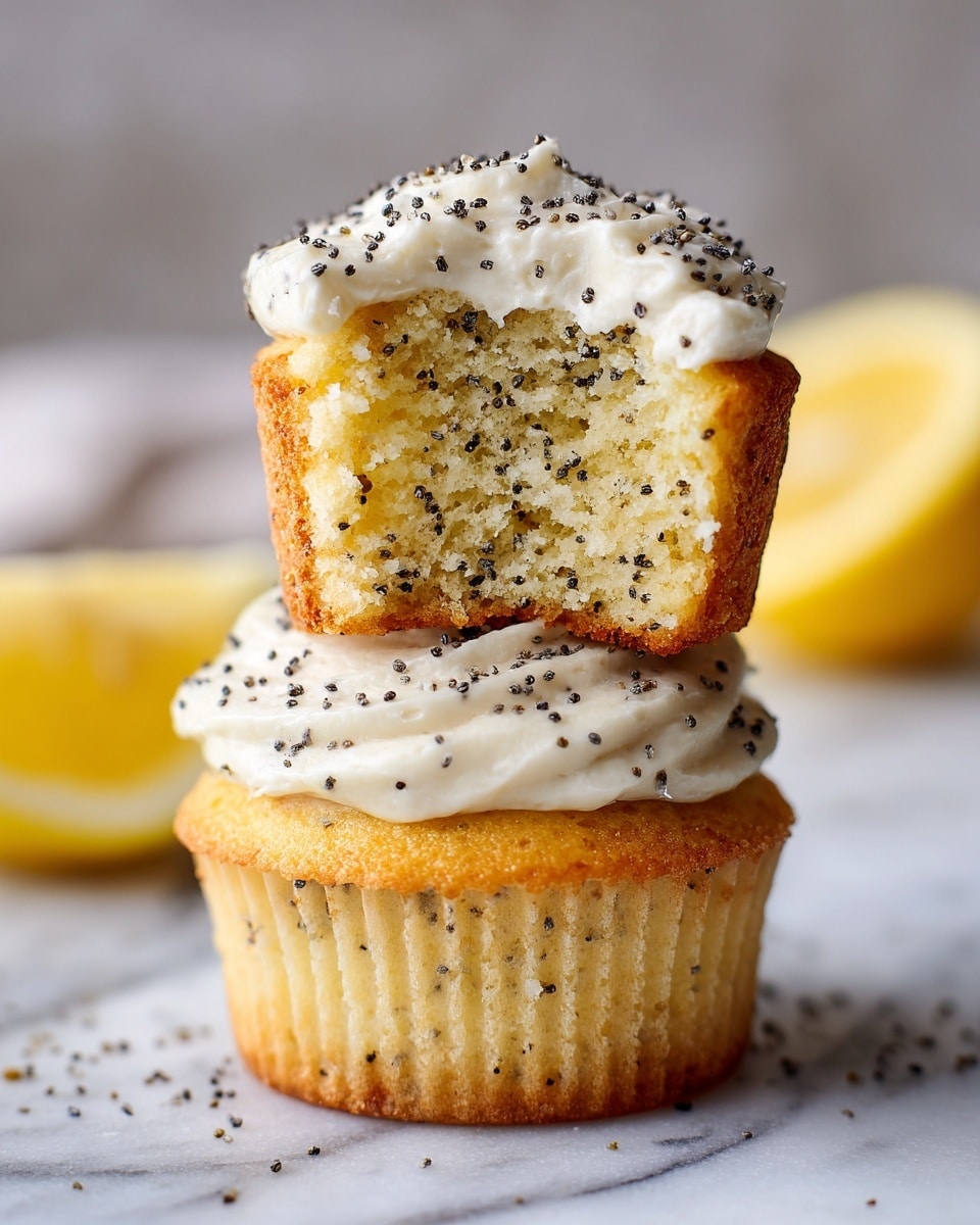 Two lemon poppy seed muffins are stacked on a white marbled surface, the bottom muffin showing a slightly golden crumb with a smooth layer of white icing topped with small black poppy seeds. The top muffin leans on the bottom one, with a bite taken out, revealing a moist, light yellow cake filled with scattered black poppy seeds. A soft white icing with poppy seeds covers the top of the muffins. A blurred half lemon is visible in the background. photo taken with an iphone --ar 4:5 --v 7