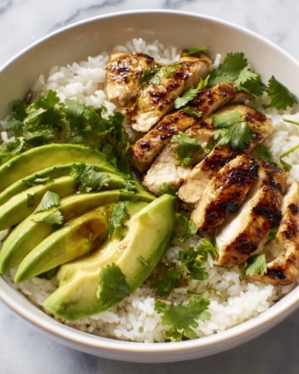 The image shows a white bowl on a white marbled surface filled with three main layers. At the bottom is a layer of white rice with a fluffy texture. On one side of the bowl, there are thin slices of grilled chicken breast with visible grill marks and a slightly brown, glazed surface. On the other side, there are neatly arranged slices of bright green avocado with slight grill marks on them. Fresh green cilantro leaves are scattered on top, adding a touch of vibrant color. Photo taken with an iphone --ar 4:5 --v 7