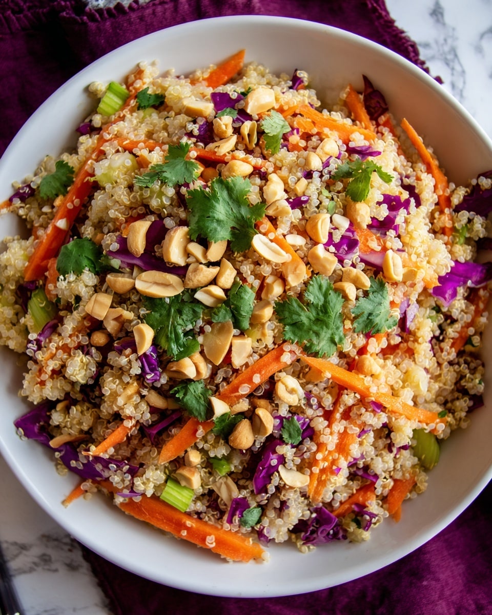 A white bowl filled with a quinoa salad showing several layers: the bottom layer is light beige cooked quinoa with a fluffy texture, mixed throughout are thin orange carrot sticks and small pieces of green herbs and onion. Above this, fresh green cilantro leaves add texture and freshness, while whole and halved light brown peanuts are scattered on top, adding a crunchy texture. The bowl sits on a white marbled surface, with a purple cloth peeking from the bottom right corner. Photo taken with an iphone --ar 4:5 --v 7