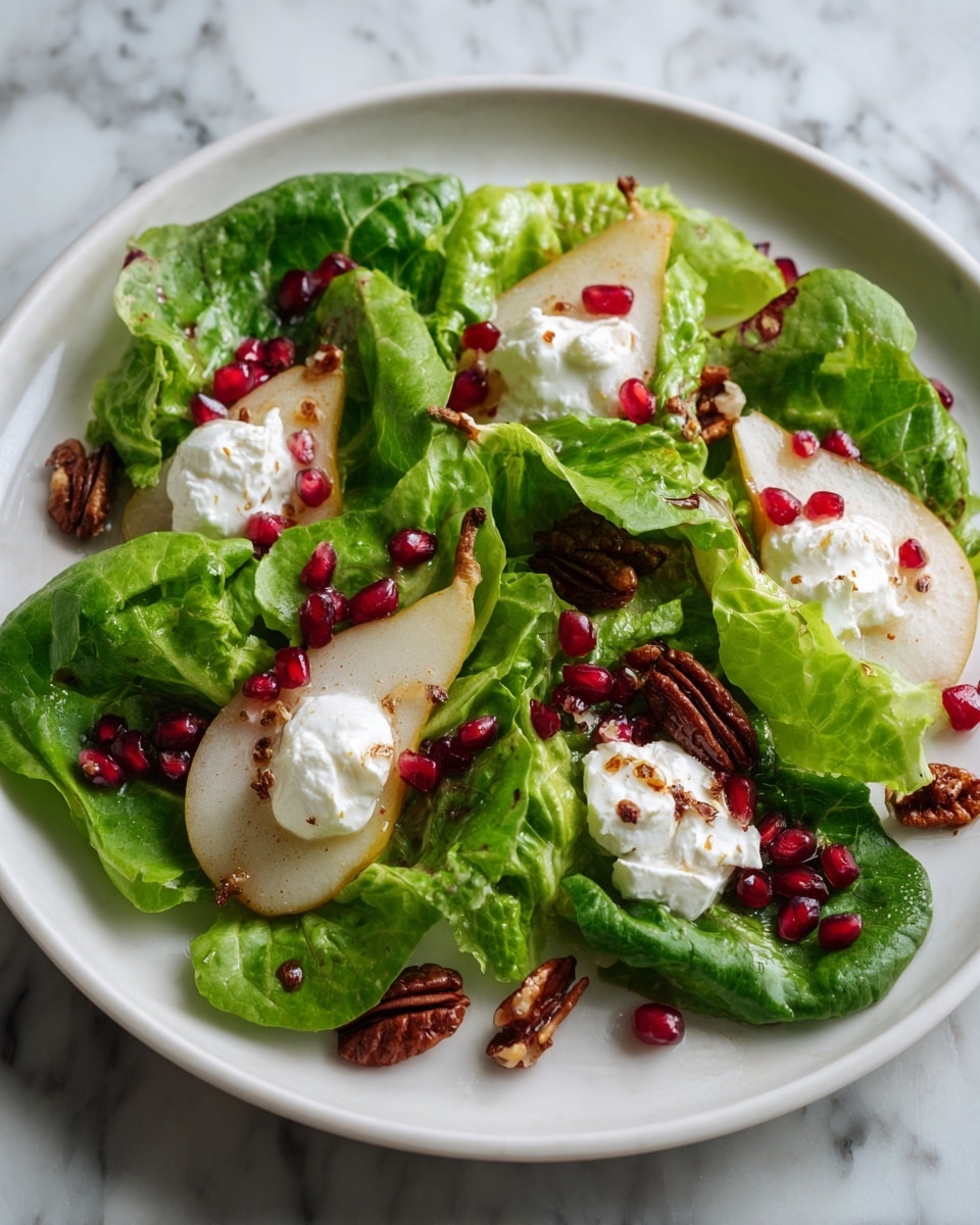 A fresh salad on a white plate with about three layers of ingredients: the bottom layer is bright green lettuce leaves spread evenly, the middle layer has deep red pomegranate seeds scattered around, light brown pecans placed in small groups, and chunks of pale tan pear pieces, and the top layer features dollops of soft white cheese with a drizzle of amber-colored dressing over it all. The plate is on a wooden table with a blurred background, focusing closely on the salad details. photo taken with an iphone --ar 4:5 --v 7