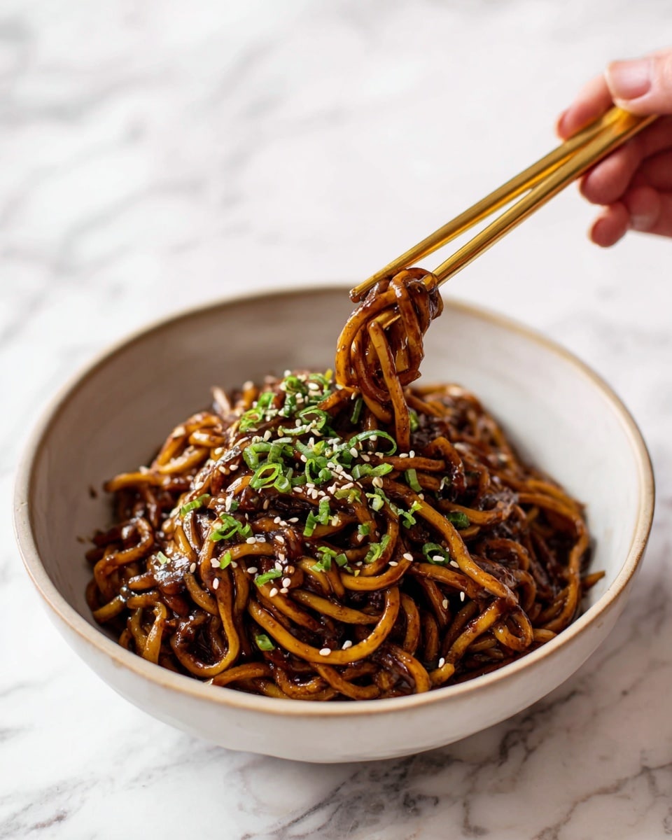 A close-up view of a bowl filled with thick, twisted noodles coated in a dark brown sauce. The noodles form one thick layer inside a simple white bowl, topped with small green chopped herbs and light sesame seeds. A pair of golden chopsticks is held by a woman's hand, lifting some noodles from the bowl. The background shows a white marbled texture. photo taken with an iphone --ar 4:5 --v 7