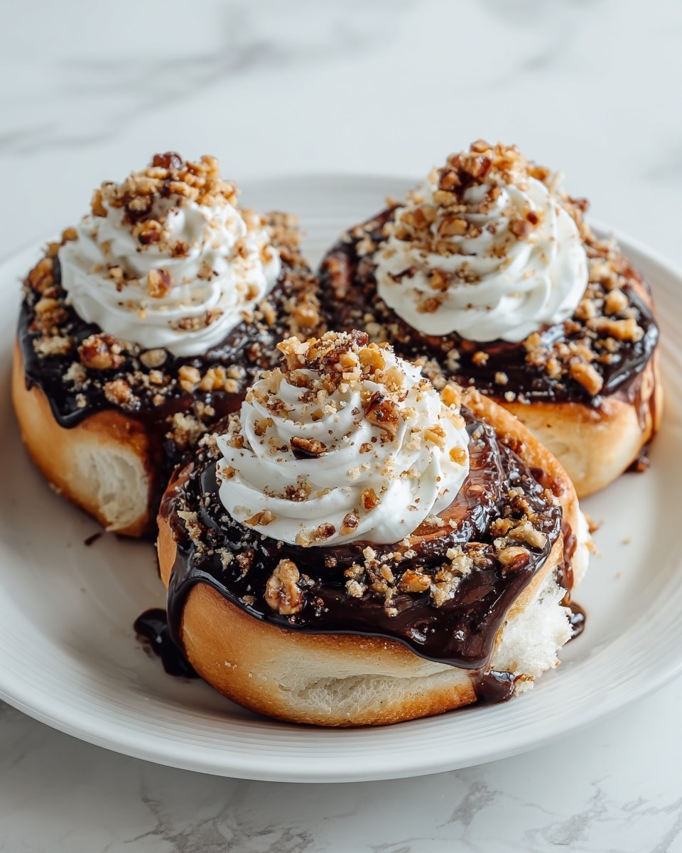 Three cinnamon rolls sit closely together on a white plate, each topped with a thick layer of glossy chocolate glaze that covers most of the top surface. On top of the chocolate glaze is a large dollop of smooth white cream, forming a swirl shape on each roll. The cream is sprinkled with crunchy, light brown crumble bits for texture. The cinnamon rolls themselves are golden brown with a soft, fluffy texture, visible around the edges beneath the chocolate and cream. The photo is taken with an iphone --ar 4:5 --v 7